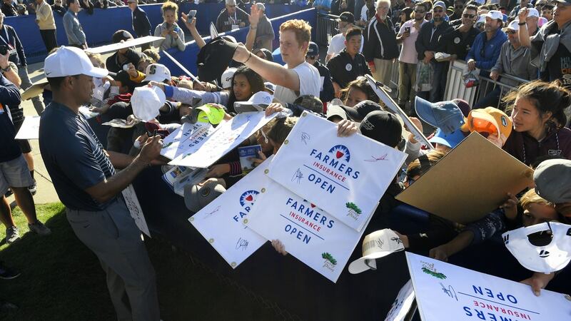 Woods signs autographs for fans at the Farmers Insurance Open. Photo: Getty Images