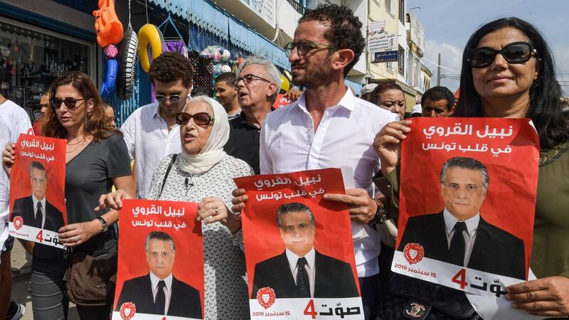 Najiba Karoui (second from left), mother of Tunisia’s jailed presidential candidate Nabil Karoui, with his sister and others holding his election poster. Photograph: Fethi Belaid/AFP