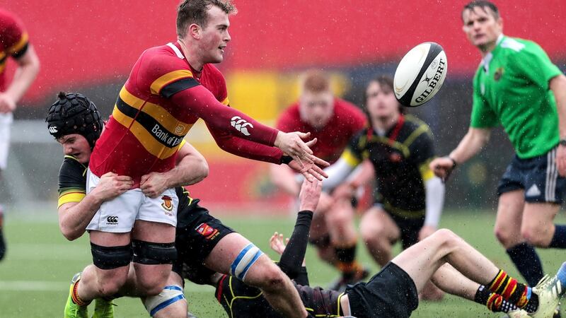 Christian Brothers School’s Conor Walsh offloads the ball despite a tackle from Jack Ward Murphy of Ardscoil Rís during the Munster Schools Senior Cup semi-final at Irish Independent Park, Cork.  Photograph: Laszlo Geczo/Inpho