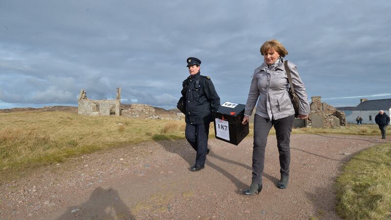 Presiding officer  Nancy Sharkey and Garda Siobhan Campbell carry the ballot box for Gola Island, off the west coast of Donegal, to the polling station.   Photograph: Alan Betson/The Irish Times