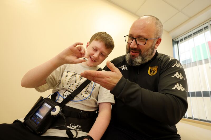 James with his dad Aidan – once James has swallowed the capsule they walk around until staff are satisfied it has reached the top of James’s small intestine. Photograph: Alan Betson/The Irish Times

