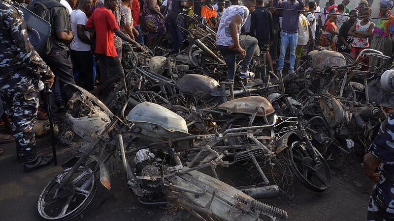Freetown residents look at burnt-out motorcycles and scooters in the aftermath of Friday’s explosion. Photograph: Mohamed Konneh/EPA