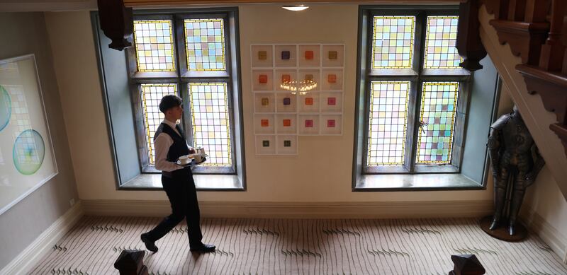Staff member Jude McCarthy walks by art in the Park Hotel Kenmare. 