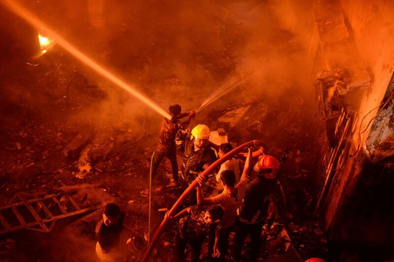 Firefighters work to try and  douse the  flames in Dhaka. Photograph: AP