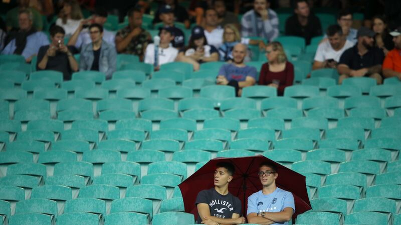 Two members of the crowd share an umbrella as they watch on during the round six Super Rugby match between the Waratahs and the Crusaders  in Sydney in March 2019. Photograph: Mark Kolbe/Getty Images