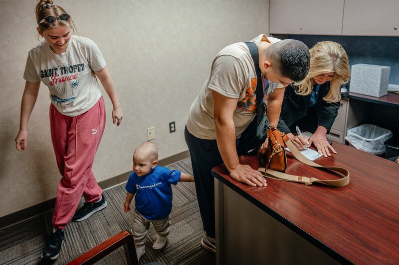 Angela Boelens (right) helps a Ukrainian refugee family secure a car loan at DeWitt Bank & Trust Co in DeWitt, Iowa. Photograph: Jamie Kelter Davis/The New York Times