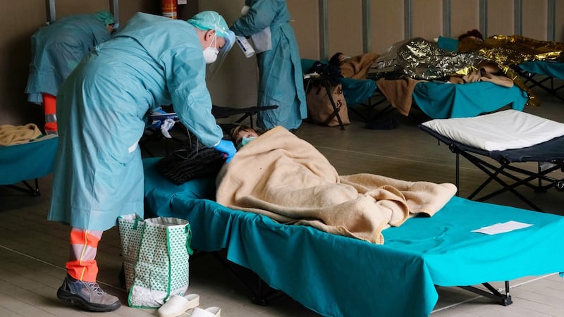 Healthcare workers and coronavirus patients at a facility set up outside Brescia Hospital in Italy in  March last year. Phorograph:  Filippo Venezia/EPA