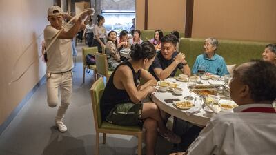An employee doing the trademark ‘noodle dance’ at a Haidilao restaurant  in Beijing. Photograph: Gilles Sabrié/ The New York Times
