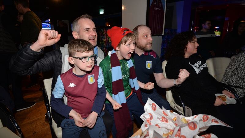 Aston Villa fan club vice-chairman James Mahon and son Leo with chairman Philip Drew and his son Nathan watch a Premier League match in Temple Bar. Photograph: Alan Betson