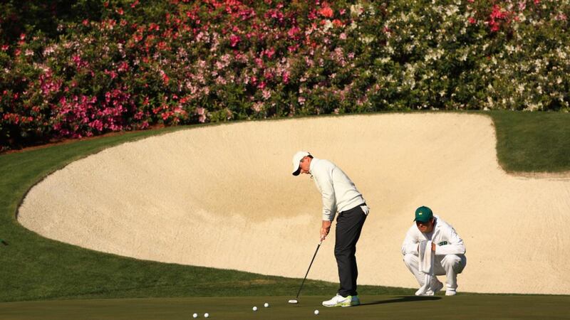Rory McIlroy  putts on the 12th green as caddie Harry Diamond looks on during a practice round prior to the Masters at Augusta National Golf Club. Photograph: Mike Ehrmann/Getty Images