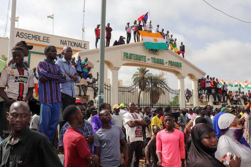 Protesters display the flag of Niger at the entrance to the National Assembly during a rally in Niamey. Photograph: Issifou Djibo/EPA