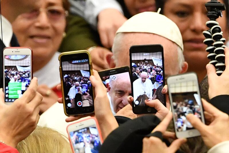2019. The faithful greet Pope Francis (Rear) and take photos of him with their mobile phone upon his arrival for the weekly general audience on January 9, 2019 at Paul-VI hall in the Vatican. Photograph: Andreas Solaro / AFP via Getty Images
