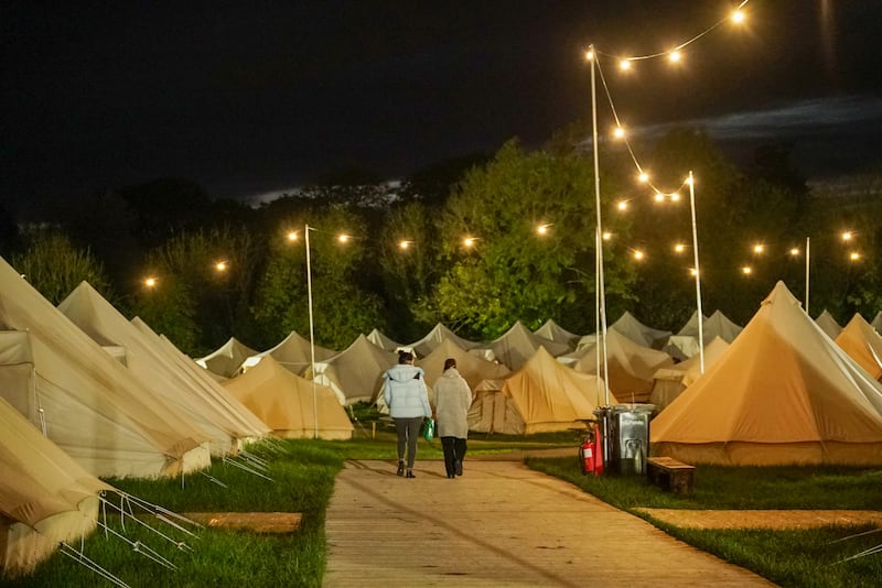 Two Ukrainian refugees walk among the tents in Stradbally where people have been staying since Electric Picnic finished in September.  Photograph: Enda O'Dowd