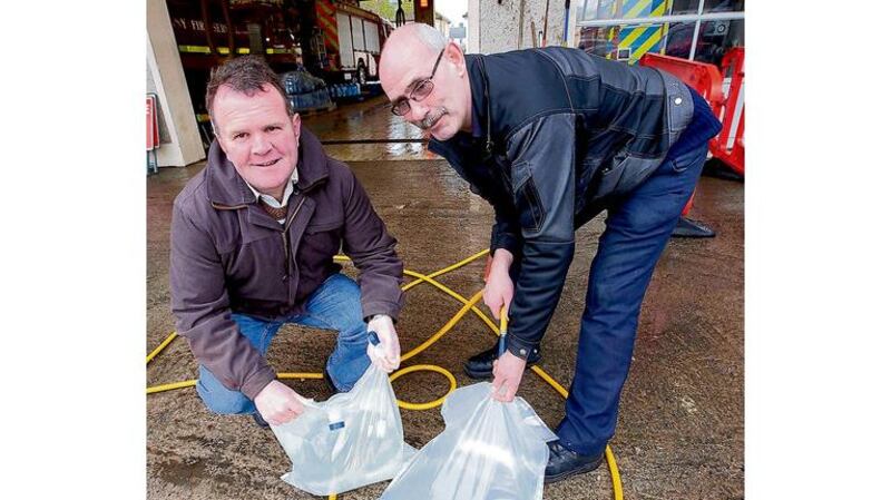 Councillor Joe Malone (left) gets water for his house from Kieran Howley of the Kilkenny Fire Service in Kilkenny city. Photographs: Alan Betson, Dylan Vaughan, Clare Keogh/ Provision