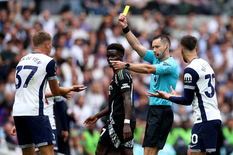 Referee Jarred Gillett shows a yellow card to Tottenham Hotspur's Micky van de Ven during Sunday's north London derby. Photograph: Adrian Dennis/AFP via Getty Images