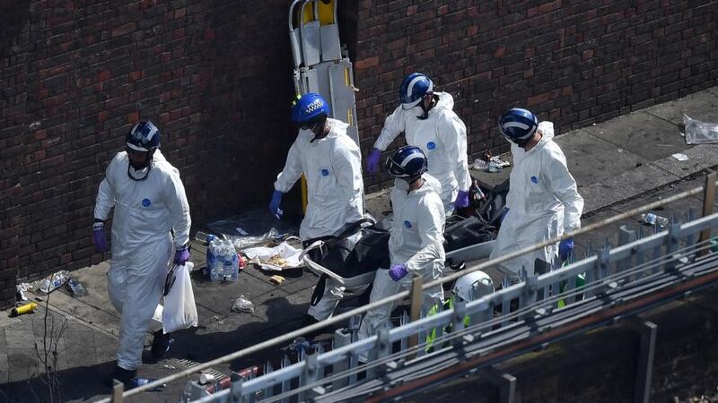 Police forensics carry a stretcher with a body bag out of Grenfell Tower. Photograph: Leon Neal/Getty Images