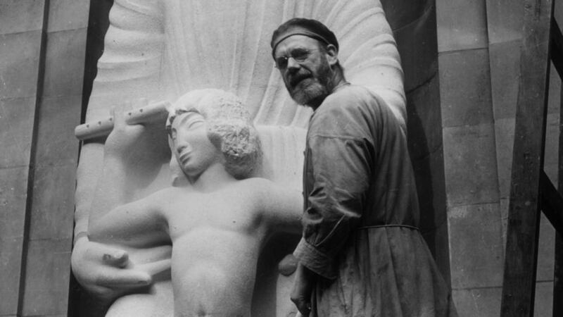 British sculptor Eric Gill with his sculpture of Ariel at the front of Broadcasting House, headquarters of the BBC,  in London. Photograph:   Howard Coster/Hulton Archive
