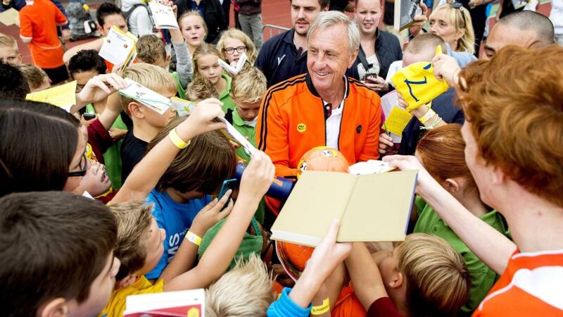 Johan Cruyff (centre) signs autographs during the annual Open Day of the Johan Cruyff Foundation at the Olympic Stadium in Amsterdam. Photograph: Koen van Weel / EPA