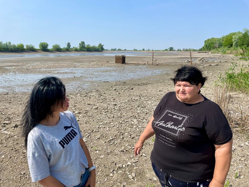 Viktoria Kryvenko, secretary of Kushuhum village council, and Lyudmyla Volyk, head of Malokaterynivka village, on the now dry bed of the Konka river that flows into the Dnipro and the Kakhovka reservoir. Photograph: Daniel McLaughlin