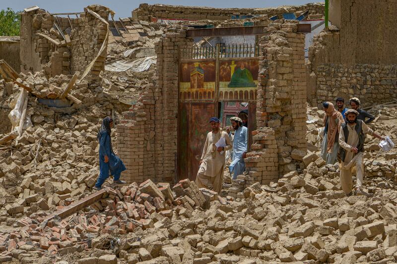 Villagers along with rescue workers examine the extent of damage at a village following an earthquake in Bernal district, Paktika province. Photograph: Ahmad Sahel Arman/AFP via Getty Images