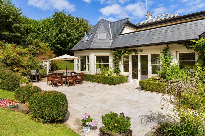 The garden at the back slopes up from a granite-paved patio the width of the house.
