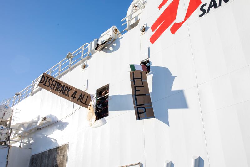 Migrants show placards demanding the disembarkation of all those on the Norway-flagged Geo Barents rescue shiP. Photograph: Massimo Di Nonno/AP