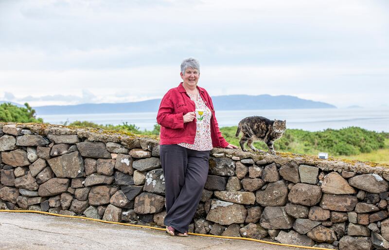 B&B owner Margaret McQuirkin with her cat  Puss Puss, with Scotland's Mull of Kintyre in the background. Photograph: Paul Faith