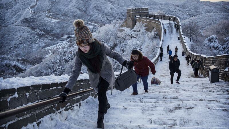 Chinese tourists walk on a slippery section of ice as snow is seen on the Great Wall after a snowfall on November 23, 2015 near Beijing, China. Photograph: Kevin Frayer/Getty Images)