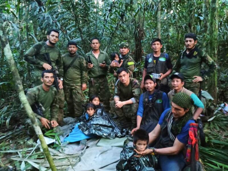 Soldiers and indigenous men pose for a photo with the four rescued children. Handout photograph: Colombia’s Armed Force Press Office via AP