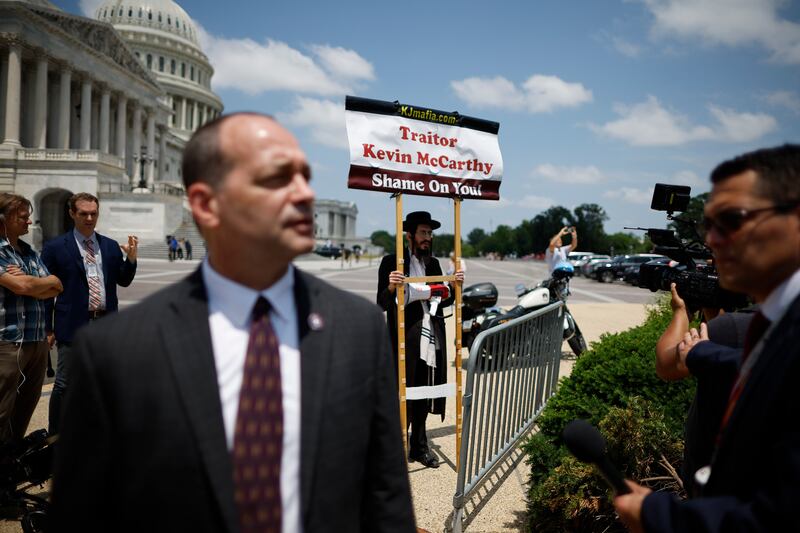 A demonstrator standing in the background as US House Freedom Caucus member Rep Bob Good (R-VA) talks to reporters in Washington, DC. Photograph: Chip Somodevilla/Getty Images