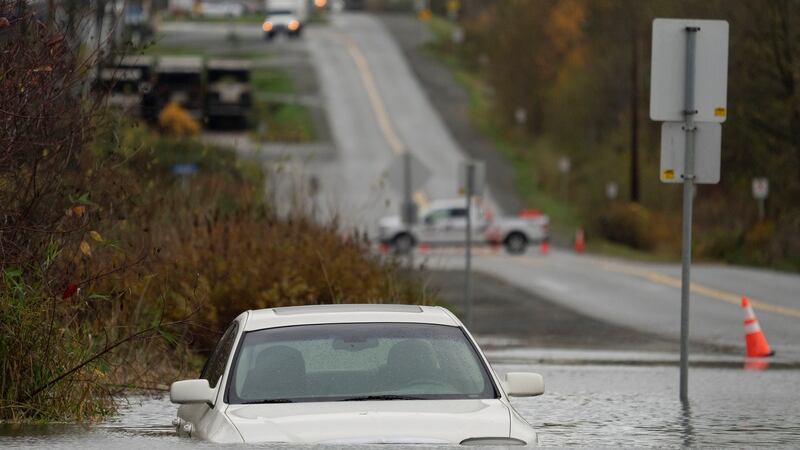 A vehicle is submerged in flood waters along a road in Abbotsford, British Columbia, Canada. Photograph: Jonathan Hayward/The Canadian Press via AP