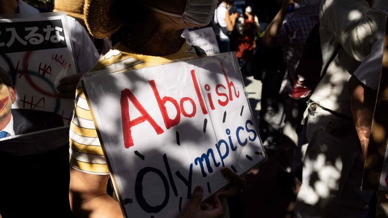 An activist holds a placard outside the hotel where International Olympic Committee president Thomas Bach is staying in Tokyo. Photograph: Yuki Iwamura/AFP