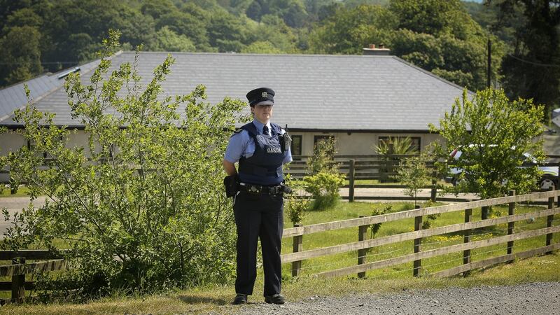 A garda stands outside the house where four children were found badly injured in Blainroe, Co Wicklow. Photograph: Garry O’Neill