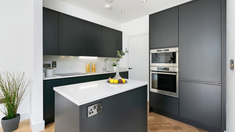 The kitchen has handless units painted in a Brokk black colour that chimes with the blackened steel plug and light switches and the matt black resin door handles