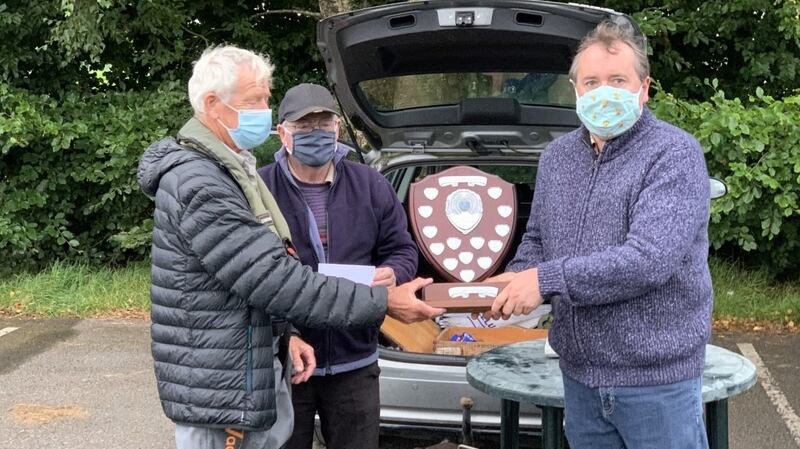 Stuart McGrane (left) receiving the Patti Doolan Memorial Shield from Michael Doolan with Stan McKeon in background.