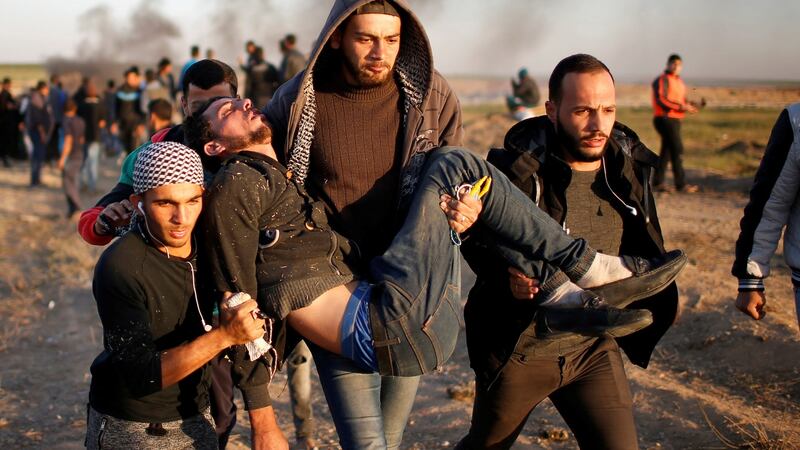 A wounded Palestinian is evacuated during clashes with Israeli troops at a protest, at the Israel-Gaza border, demanding the right to return to their homeland, east of Gaza City on April 1, 2018. Photographer:  REUTERS/Mohammed Salem
