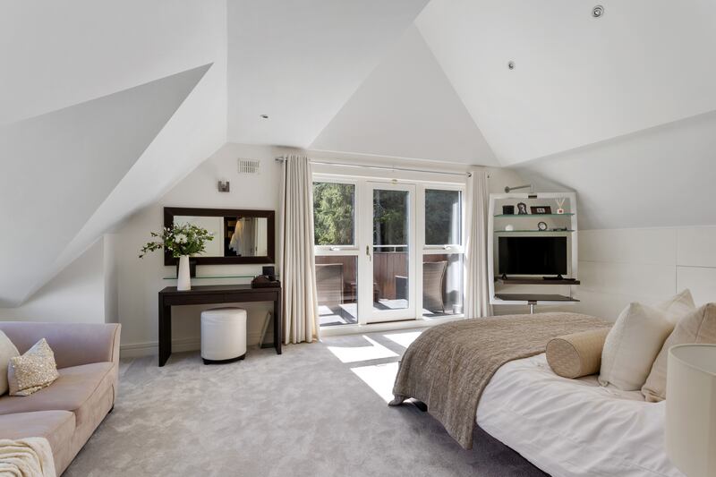 The main bedroom suite has an impressive vaulted ceiling and  dramatic views over the gardens, plus lots of integrated storage space. 