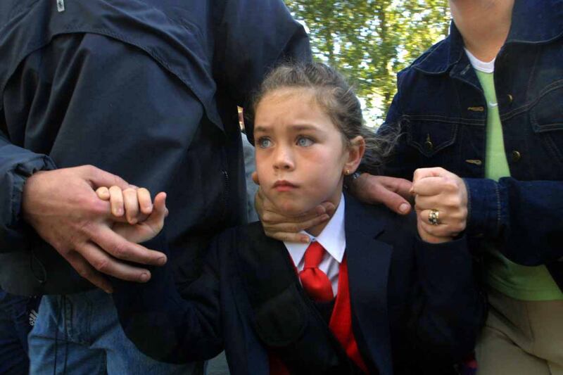 A Catholic girl is shielded by police as she is brought to Holy Cross primary school in September 2001. Photograph: RollingNews.ie
