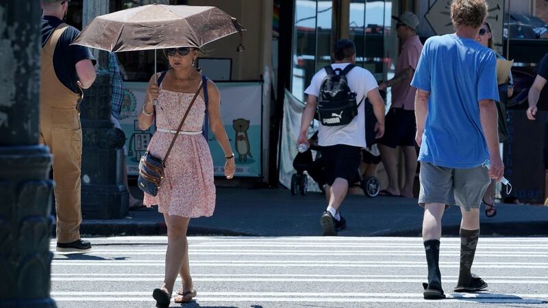 A person uses an umbrella for shade from the sun while walking near Pike Place Market  in Seattle. Photograph: Ted Warren/AP