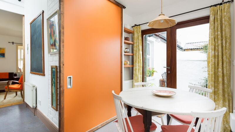 A small breakfast area at 2 Eden Road Lower in Glasthule can be screened off by closing a large, amber orange sliding door.