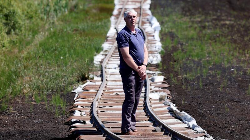 Declan Killian, Bord na Móna train driver,  on the last rail line to the remaining peat stockpiles on the Boora Bog near Ferbane. Photograph: Alan Betson / The Irish Times