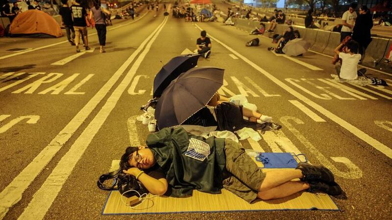 A pro-democracy protester sleeps on the road outside the Hong Kong Government Complex today. Demonstrations over autonomy for the area have entered their second week.  Photograph:  Thomas Campean/Getty Images.