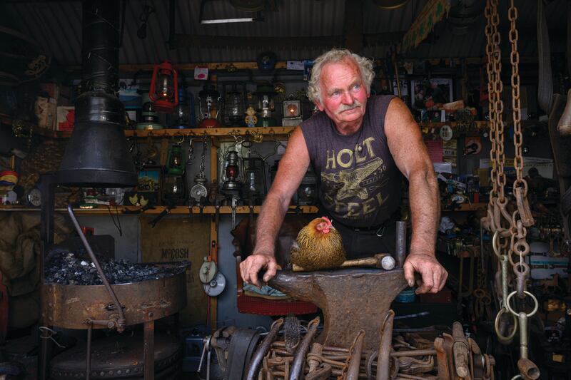 FORGING FRIENDSHIPS: Ben Burke, master blacksmith from Foxford, Co Mayo, works his travelling forge with ‘Penny’, his partridge Pekin Bantam, perched on the anvil.
Photograph: Michael McLaughlin / Freelance
