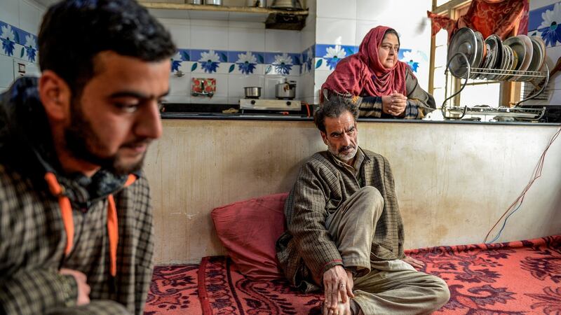 Mohamad Altaf, (centre), who was shot once in the back of his right knee by Sameer Tiger, and his wife Fareeda Akhtar at their home in Qasbayar, India, in the state of Kashmir. Photograph: Atul Loke/New York Times