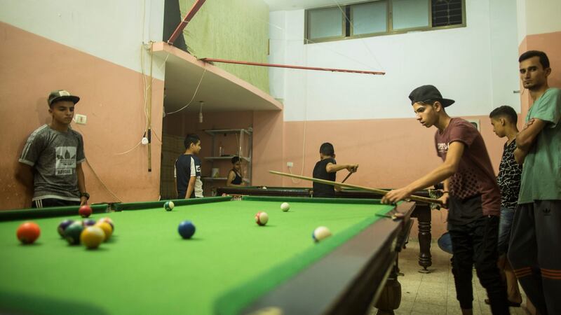 Palestinian youths play pool on Tuesday this week during the few hours of mains electricity the residents of the Gaza Strip enjoy  every day. Photograph: Mahmud Hams/AFP/Getty Images