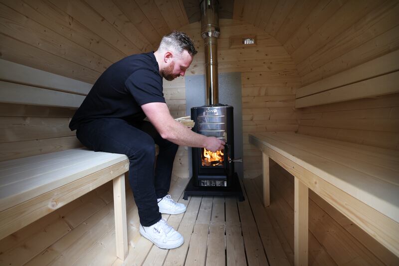 John Needham of Sauna Craft Co lights up the sauna in the back garden  of his house. Photograph: Bryan O’Brien
