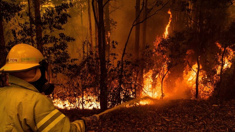 Firefighters who had redeployed from Darwin, in Australia's far north, battle a wildfire in the vicinity in Tomerong, New South Wales, Australia, Jan. 4, 2019.  High winds and temperatures over 100 degrees Fahrenheit were likely to exacerbate fires already raging out of control on Saturday; Officials in New South Wales said they expected to lose more houses over the weekend. (Matthew Abbott/The New York Times)