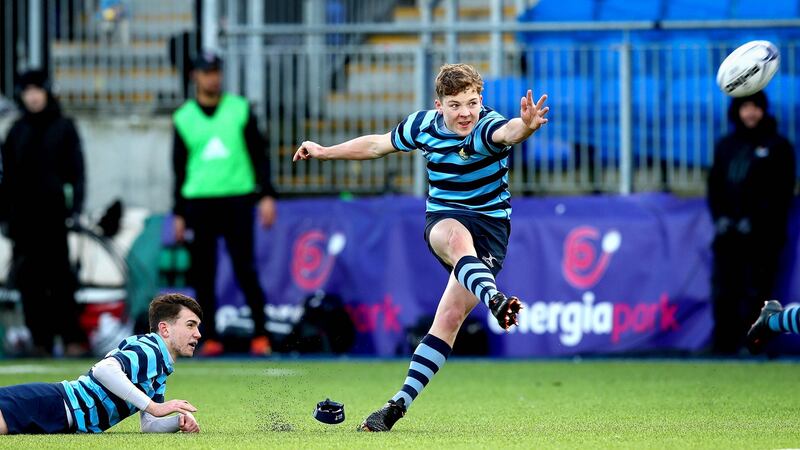 Louis McDonagh kicks the winning penalty for Castleknock against Belvedere. Photograph: Ryan Byrne/Inpho
