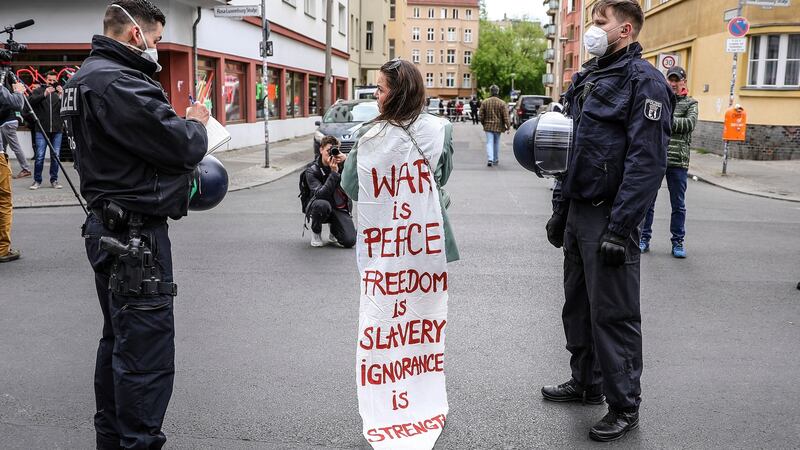 Riot police escort a demonstrator wrapped in a banner that reads War Is Peace, Freedom Is Slavery, Ignorance Is Strength – a quote from George Orwell’s novel 1984.  Photograph: EPA