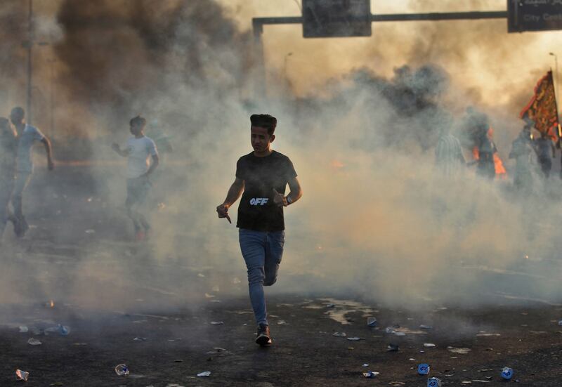 Iraqi demonstrators run amidst smoke from burning tyres during a demonstration against state corruption, failing public services, and unemployment, in the Iraqi capital Baghdad on Saturday. Photograph: Ahmad Al-Rubaye/AFP/ Getty Images